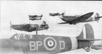 Supermarine Spitfire Mark VB, of No 457 Squadron RAAF returning to Redhill, Surrey, after a sweep over northen France, whilst another Squadron aircraft stands at its dispersal point, plugged into a trolley accumulator at readiness.