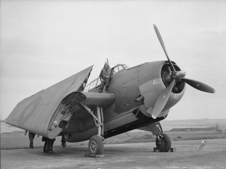 Sub Lieutenant (A) K F B Petrie, RNZNVR, of Christchurch, New Zealand, climbing into his new American built Grumman Avenger three seater torpedo bomber with its wings folded prior to taking off on exercise at HMS SPARROWHAWK, the Royal Naval Air Station at Hatston. Note the fact that the torpedo is fully enclosed so as to improve the aerodynamics of the aircraft.
. IWM (A 19925)