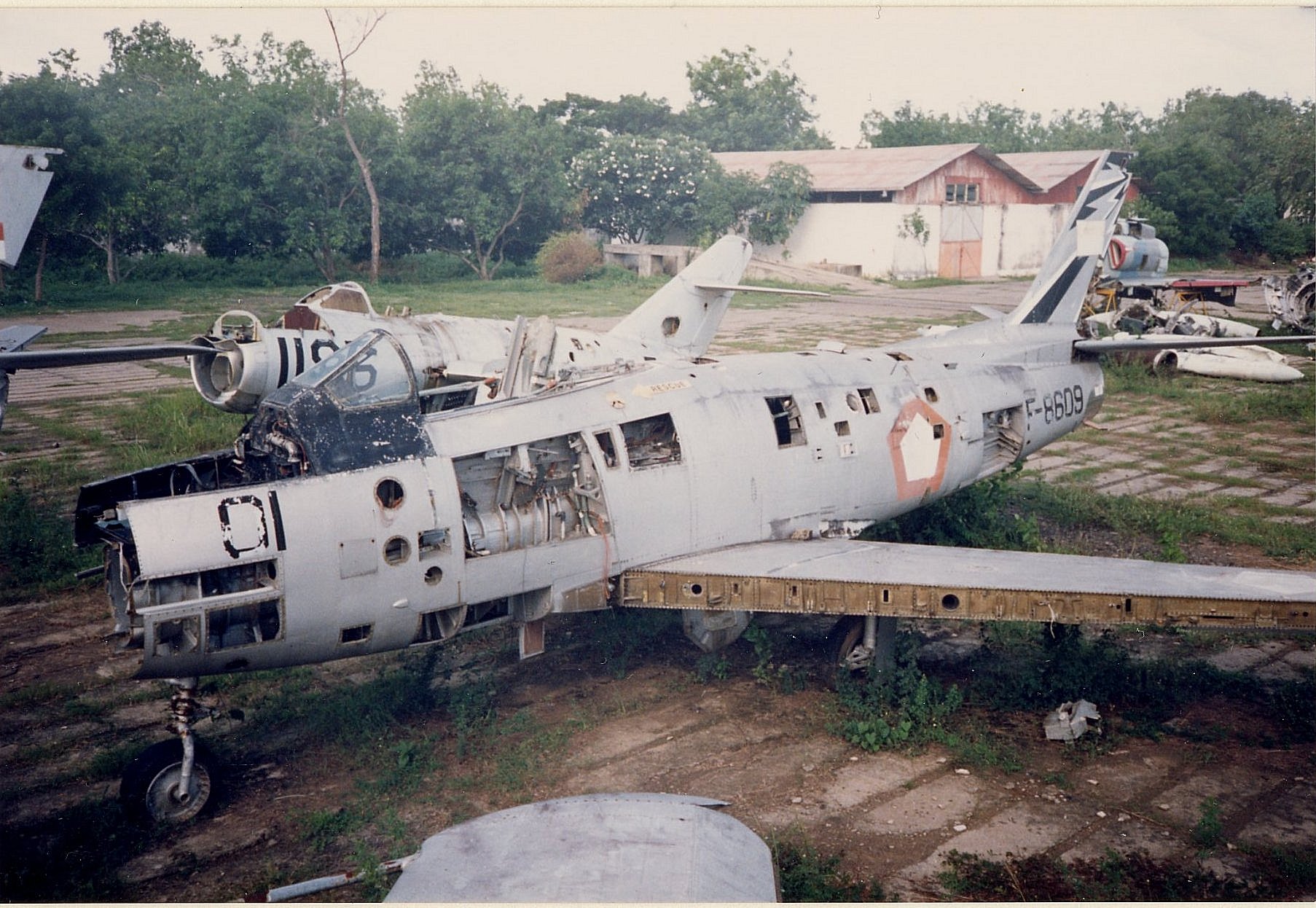 Front
                          half of F-8601 with rear of F-8609 Note
                          derelict MiG behind Photo provided by Duncan
                          Curtis